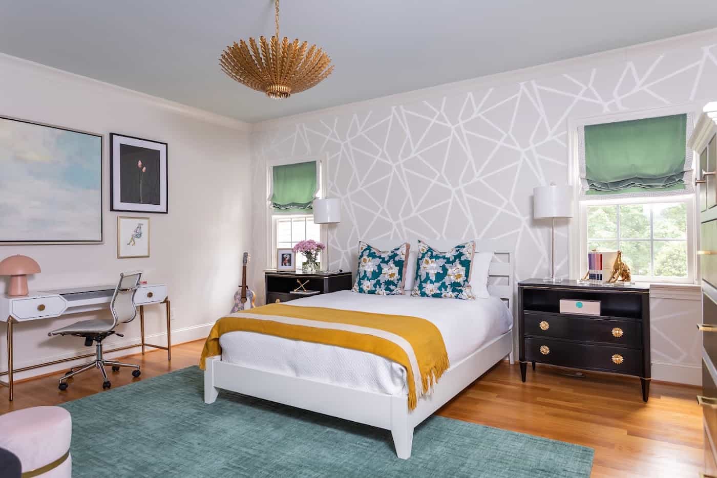 Bright primary bedroom with patterned wallpaper, white bed and gold throw designed by The Couture Haus